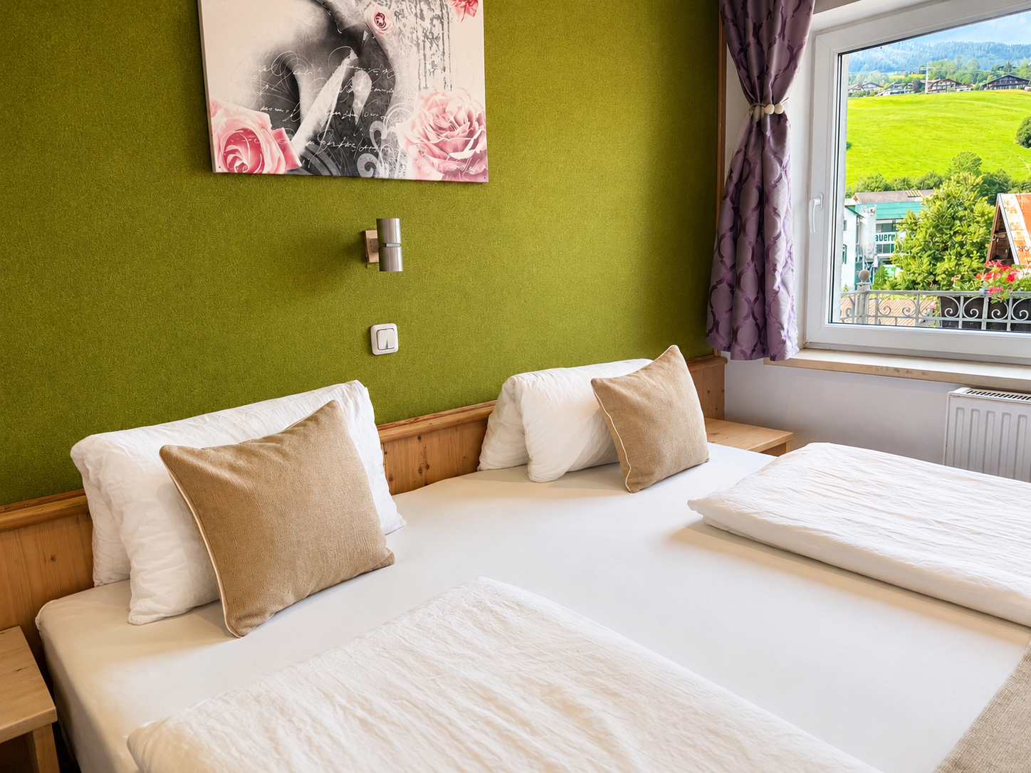 Helles Mehrbettzimmer mit Boxspringbetten und Schreibtisch